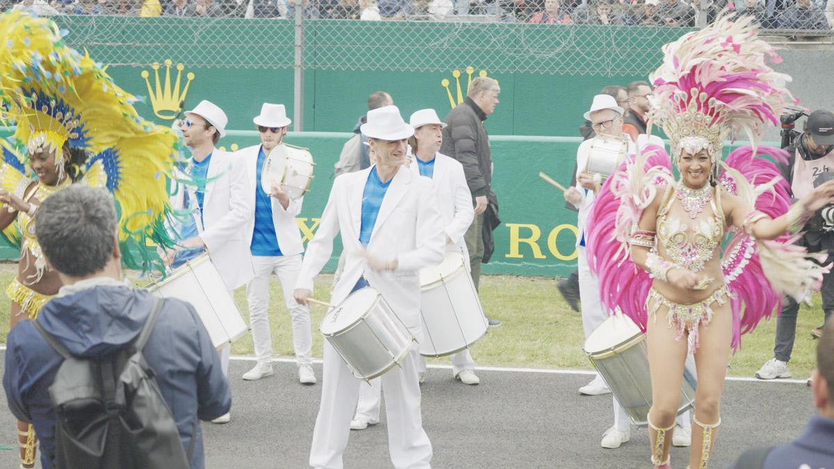 Groupe de percussions brésiliennes et danseuses samba en défilé